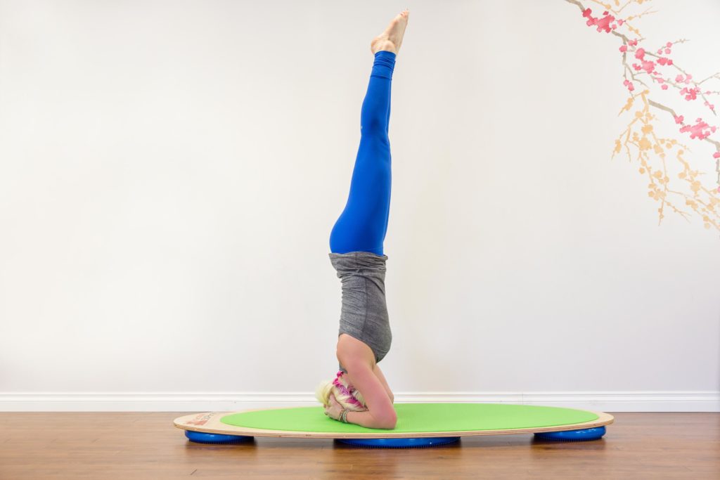 Julie Thayer in headstand on Karma SUPtra SUP Yoga board